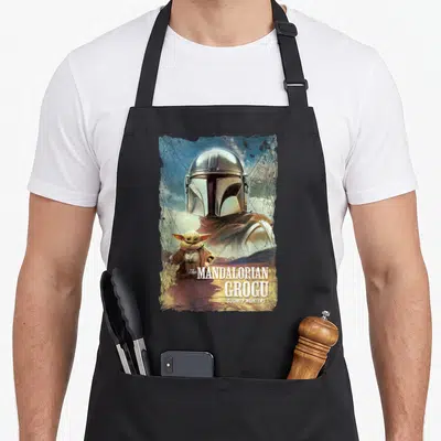 Tablier de cuisine noir avec illustration vintage du Mandalorian et Grogu et le texte The MANDALORIAN and GROGU BOUNTY HUNTERS