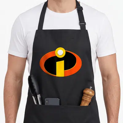 Tablier de cuisine noir avec le logo des Indestructibles en orange noir et jaune au centre.