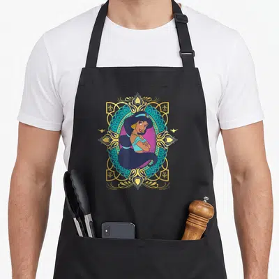 Tablier de cuisine noir avec illustration de Jasmine encadrée par un motif ornemental doré et turquoise, flanqué de deux lampes magiques.