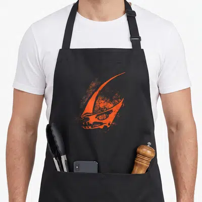 Tablier de cuisine noir avec le signe orange du Mudhorn imprimé au centre du torse.
