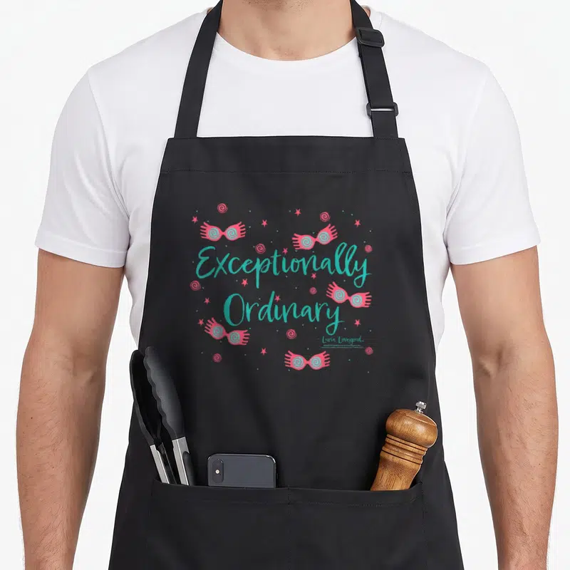 Tablier de cuisine noir avec lunettes roses flottantes et texte turquoise Exceptionally Ordinary.