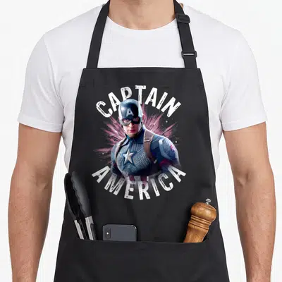 Tablier de cuisine noir avec une illustration de Captain America et le texte Captain America en blanc.
