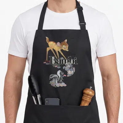 Tablier de cuisine noir avec illustration de Bambi, Thumper, Flower et le logoDisney en lettres noires.