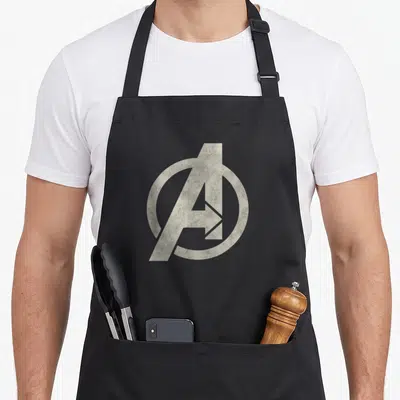 Tablier de cuisine noir avec le logo Avengers vintage A en gris clair texturé au centre du devant.