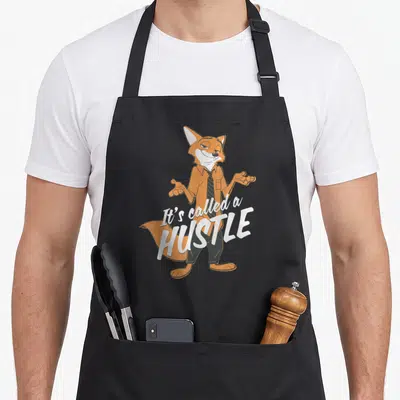 Tablier de cuisine noir avec l'illustration du renard Nick Wilde et le texte It's Called a Hustle en blanc.
