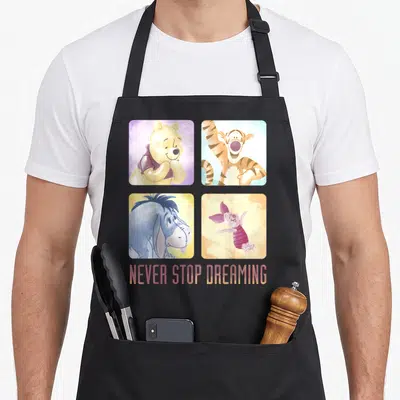 Tablier Disney Winnie l'Ourson Friends Never Stop Dreaming — sur un tablier de cuisine noir, fond blanc