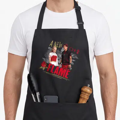 Tablier de cuisine noir avec Nova et Victor et le texte A New Flame en rouge et jaune.