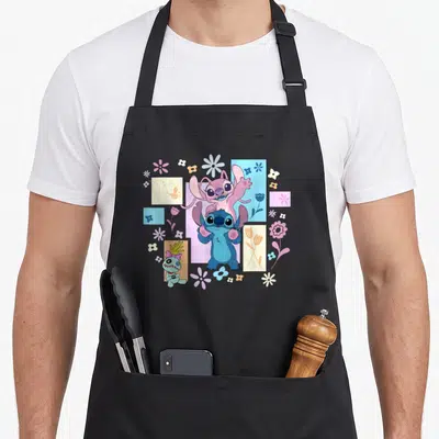Tablier de cuisine noir avec Stitch, Angel et des fleurs printanières colorées sur fond géométrique.