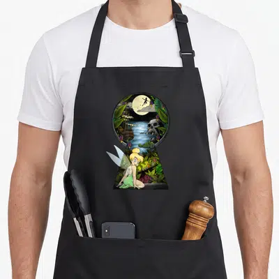 Tablier de cuisine noir avec illustration de la Fée Clochette et une scène nocturne sur l'île de Peter Pan.