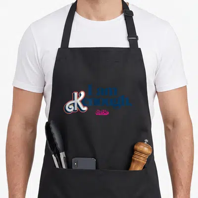 Tablier de cuisine noir avec inscription Je suis Kenough et logo Barbie en rose et bleu marine.