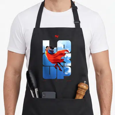 Tablier de cuisine noir avec illustration Superman et Lois dans les nuages et texte bleu