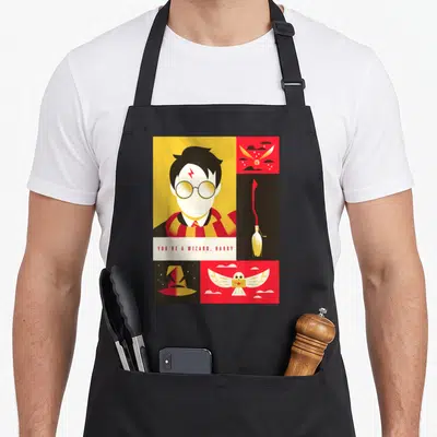 Tablier de cuisine noir avec illustration géométrique colorée représentant un sorcier aux lunettes rondes et des symboles magiques.