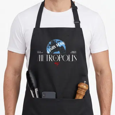 Tablier de cuisine noir avec le globe bleu du Daily Planet, le mot Metropolis en blanc et le logo S rouge.