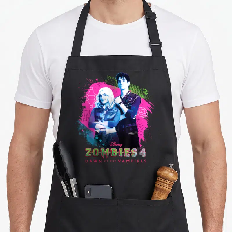 Tablier de cuisine noir avec illustration de Zed et Addison du film Zombies 4 et leurs noms stylisés en bas.