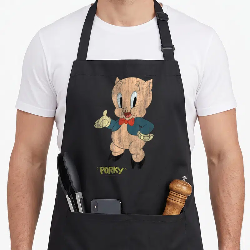 Tablier de cuisine noir avec Porky Distressed en costume bleu et nœud papillon rouge, style vintage dégradé.