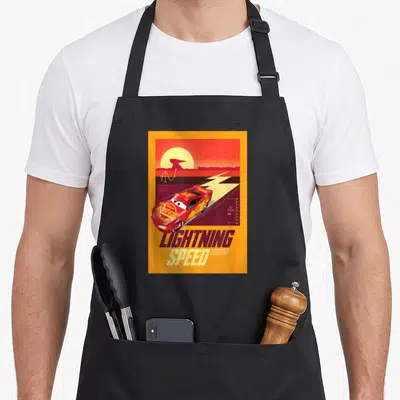 Tablier de cuisine noir avec illustration rétro d'une course de Lightning Speed McQueen sur fond orange et rouge.