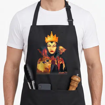 Tablier de cuisine noir avec une illustration de la Reine Maléfique tenant un pommeau rouge devant un village.