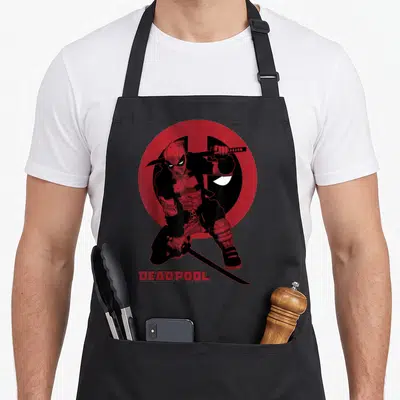 Tablier de cuisine noir avec Deadpool en position de combat samouraï et katana sur fond de cercle rouge.
