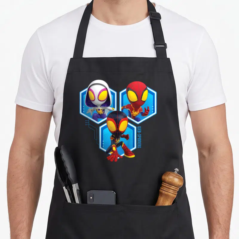 Tablier de cuisine noir avec trois personnages de super-héros en tenue colorée sur fond hexagonal bleu.