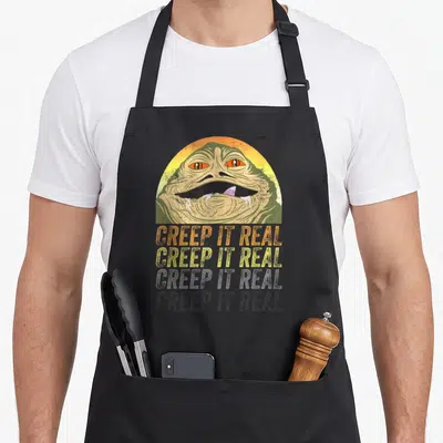 Tablier de cuisine noir avec portrait vintage de Jabba le Hutt et texte Creep It Real en trois lignes colorées