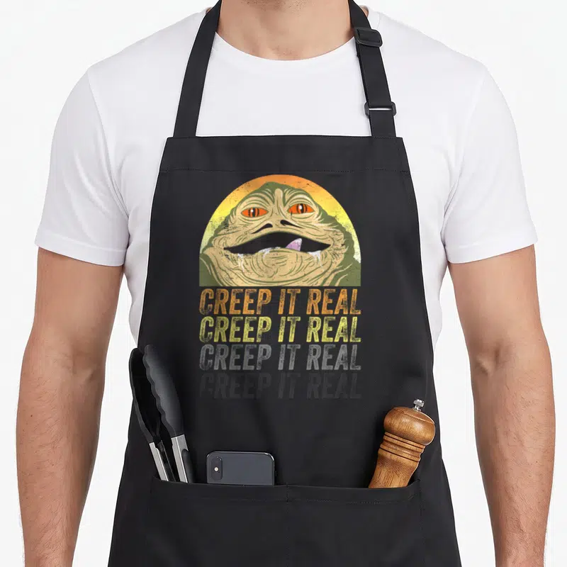 Tablier de cuisine noir avec portrait vintage de Jabba le Hutt et texte Creep It Real en trois lignes colorées