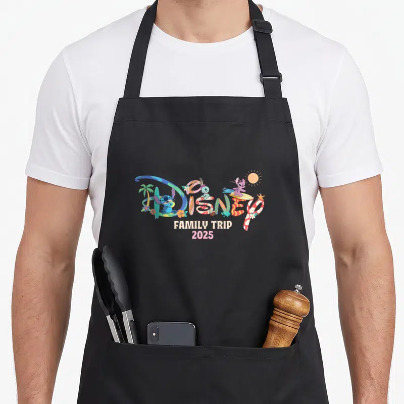 Tablier de cuisine noir avec motif Disney Family Trip 2025 Vacation coloré sur fond uni.