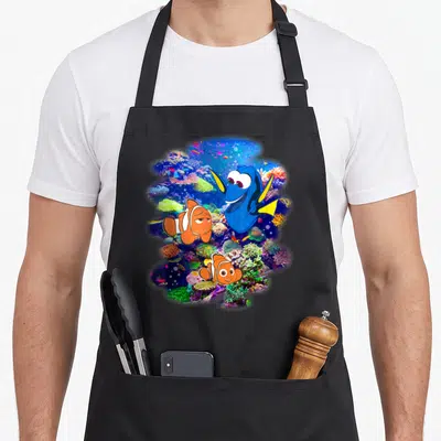 Tablier de cuisine noir avec Dory, Nemo et Marlin au milieu des coraux du Rainbow Reef.