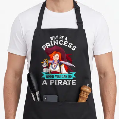Tablier de cuisine noir avec illustration d'une Pirate Girl aux cheveux roux tenant un sabre sous une bannière bleue.