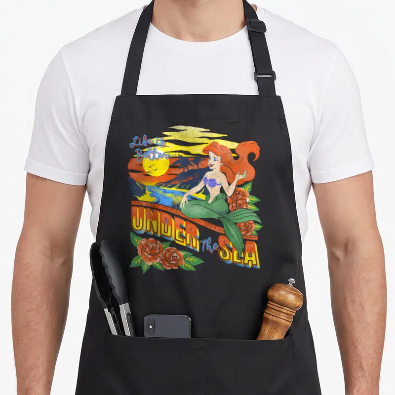 Tablier de cuisine noir avec illustration Ariel Under the Seastyle tropical vintage et roses rouges.