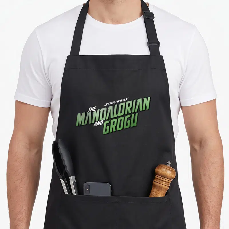 Tablier de cuisine noir avec le logo vert The Mandalorian and Grogu Star Wars imprimé au centre.