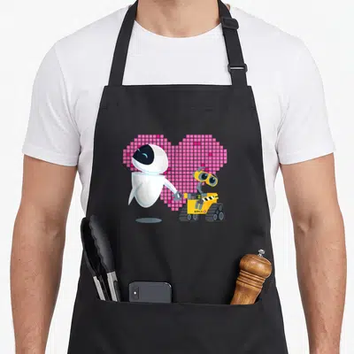 Tablier de cuisine noir avec Wall-E et Eve tenant la main devant un cœur rose pixelisé.