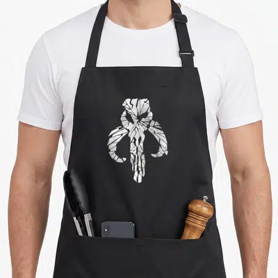 Tablier de cuisine noir avec un crâne stylisé en blanc cassé aux lignes brisées et géométriques sur le devant.