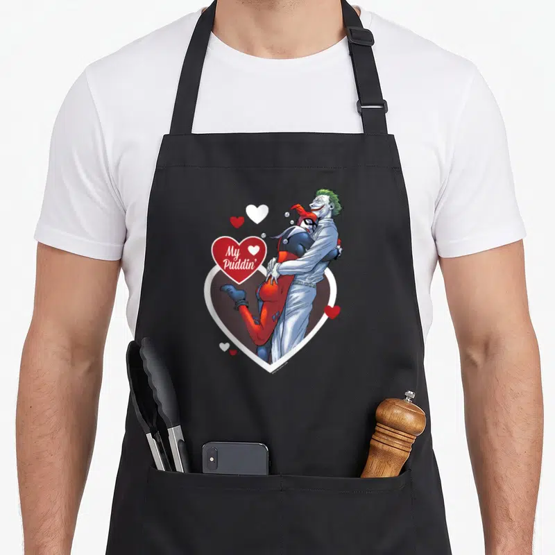 Tablier de cuisine noir avec Harley Quinn et le Joker s'enlaçant autour d'un cœur rouge portant l'inscription My Puddin'.