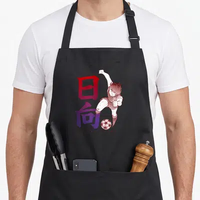Tablier de cuisine noir avec illustration de Kojiro Hyuga effectuant un botter puissant sous des caractères japonais rouges et violets.