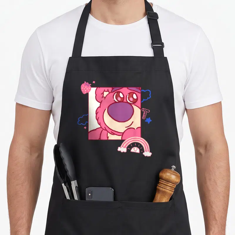 Tablier de cuisine noir avec illustration de Lotso ours rose, arc-en-ciel et fraise.