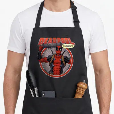 Tablier de cuisine noir avec Deadpool pointant vers le haut et une bulle de dialogue humoristique.