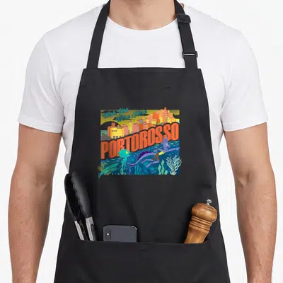 Tablier de cuisine noir avec illustration colorée de Portorosso et deux créatures marines nageant dans l'eau bleue.