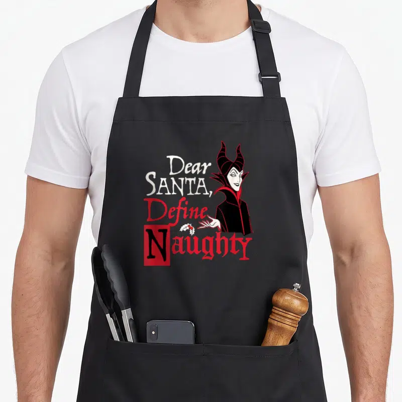 Tablier de cuisine noir avec Maléfique et le texte Dear Santa Define Naughty en rouge et blanc.