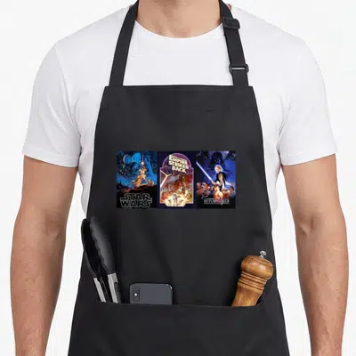 Tablier de cuisine noir avec les trois affiches originales de Star Wars en style rétro.