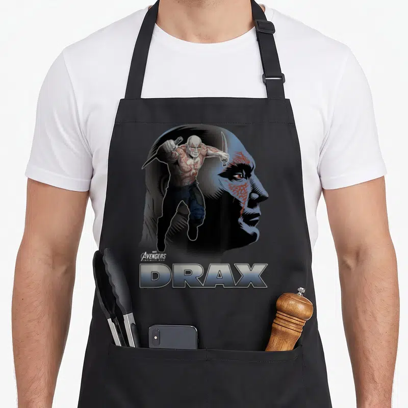 Tablier de cuisine noir avec illustration Drax Avengers Infinity War et son nom en grosses lettres métalliques.