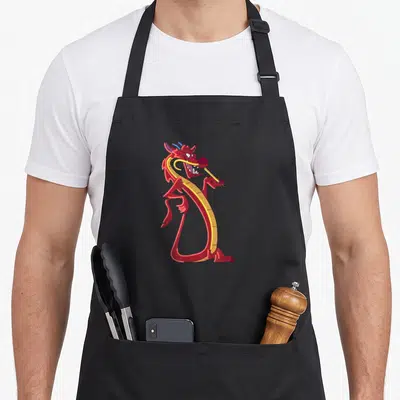 Tablier de cuisine noir avec le dragon Mushu dessiné en couleurs vives et style néon sur le devant.