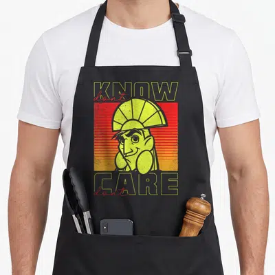 Tablier de cuisine noir avec illustration rétro de Kuzco et texte Don't Know Don't Care en jaune et rouge.