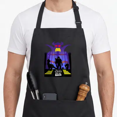 Tablier de cuisine noir avec silhouette de l'empereur Zurg et logos Toy Story en bas.