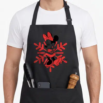 Tablier de cuisine noir avec Minnie Mouse en outline rouge sur un grand flocon de neige géométrique.