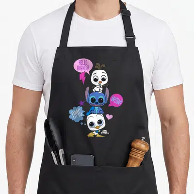 Tablier de cuisine noir avec Olaf, Stitch et Donald Duck en pyramide et bulles de dialogue colorées.