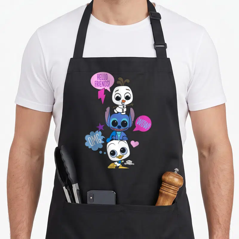 Tablier de cuisine noir avec Olaf, Stitch et Donald Duck en pyramide et bulles de dialogue colorées.