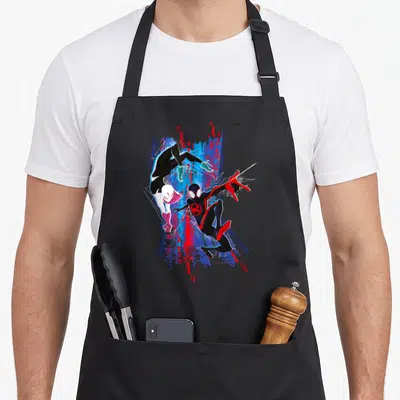 Tablier de cuisine noir avec Miles Morales et Gwen Stacy en pleine action sur un fond numérique bleu et rouge.