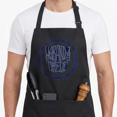 Tablier de cuisine noir avec logo circulaire bleu représentant un masque de panthère stylisé par des lettres Wakanda Forever.