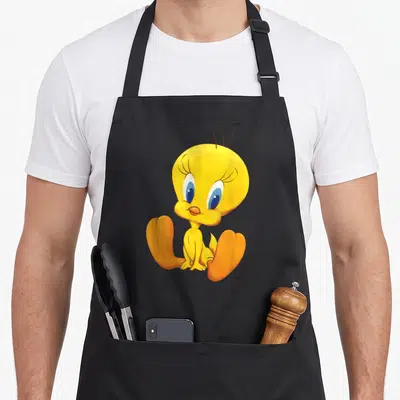 Tablier de cuisine noir avec illustration colorée de Tweety assis, plumage jaune et bec orange.