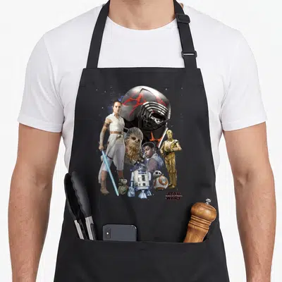 Tablier de cuisine noir avec illustration regroupant Rey, Kylo Ren, Chewbacca, Finn, C-3PO et les droïdes BB-8 et R2-D2.